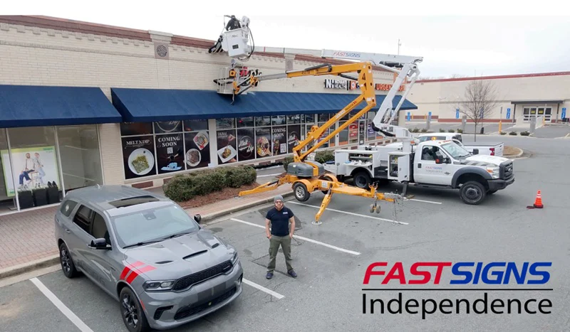 An image of a bucket truck for FASTSIGNS Independence installing an exterior sign.